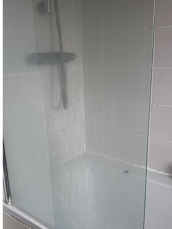 Before: the shower enclosure with grimy glass and tiles
